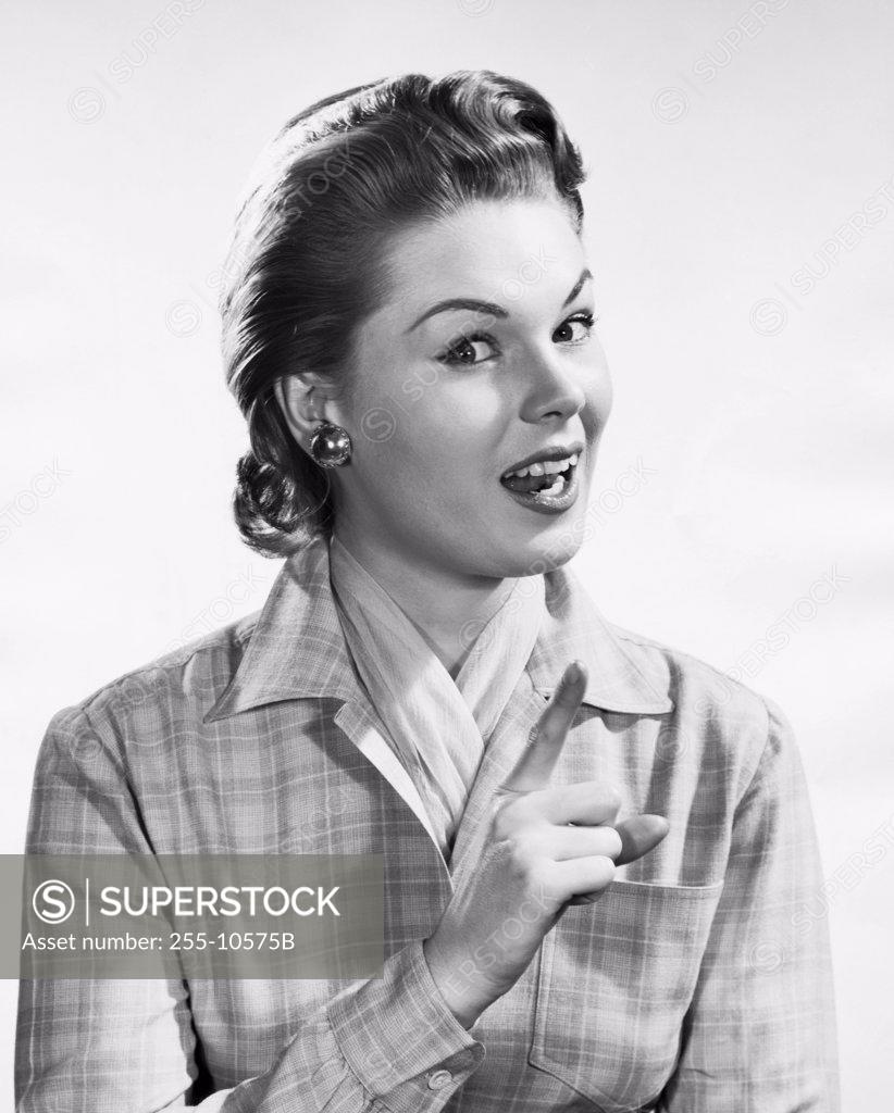 Stock Photo: 255-10575B Portrait of a young woman pointing upwards