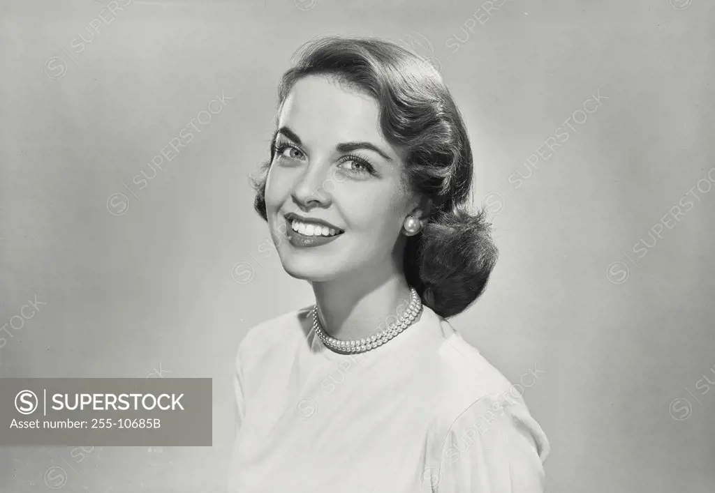 Brunette woman turned to side and smiling at camera