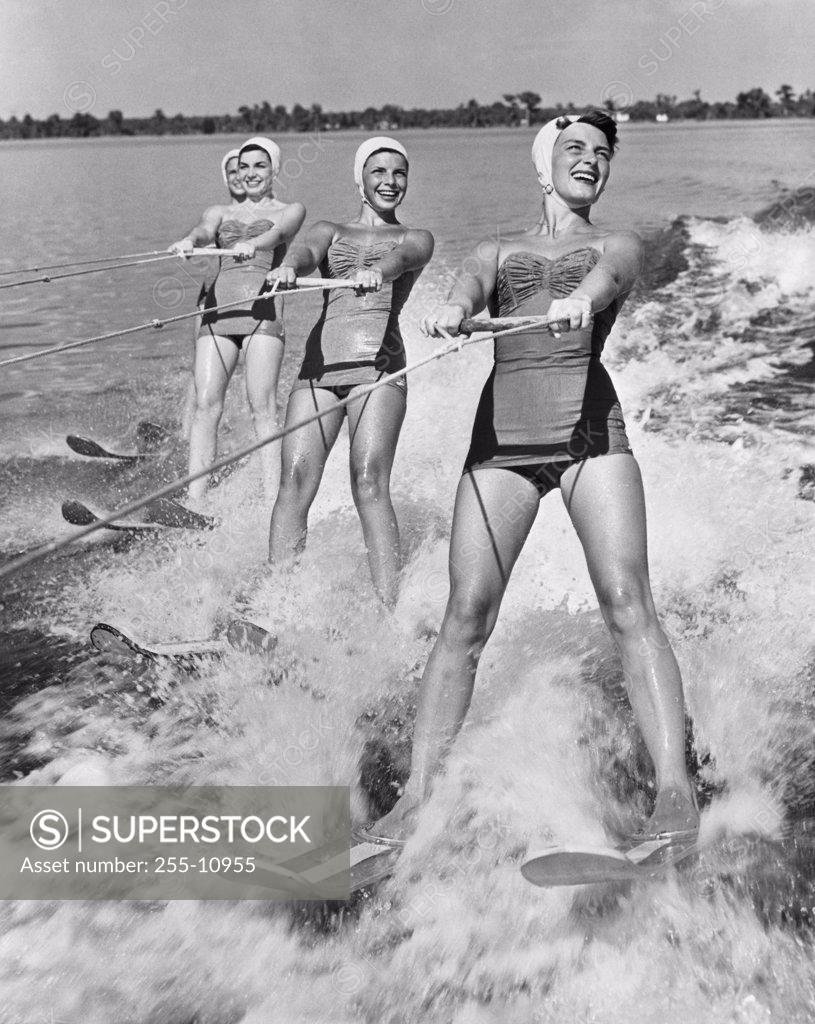 Stock Photo: 255-10955 Four young women waterskiing in the sea
