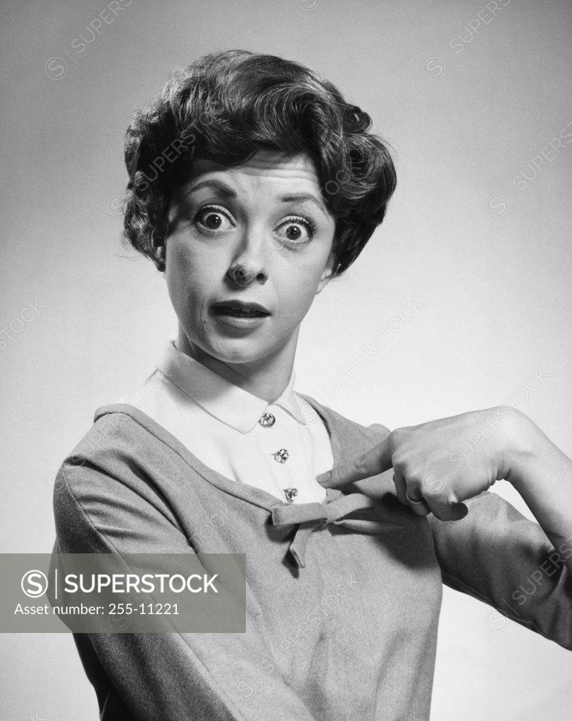 Stock Photo: 255-11221 Portrait of a young woman pointing to herself