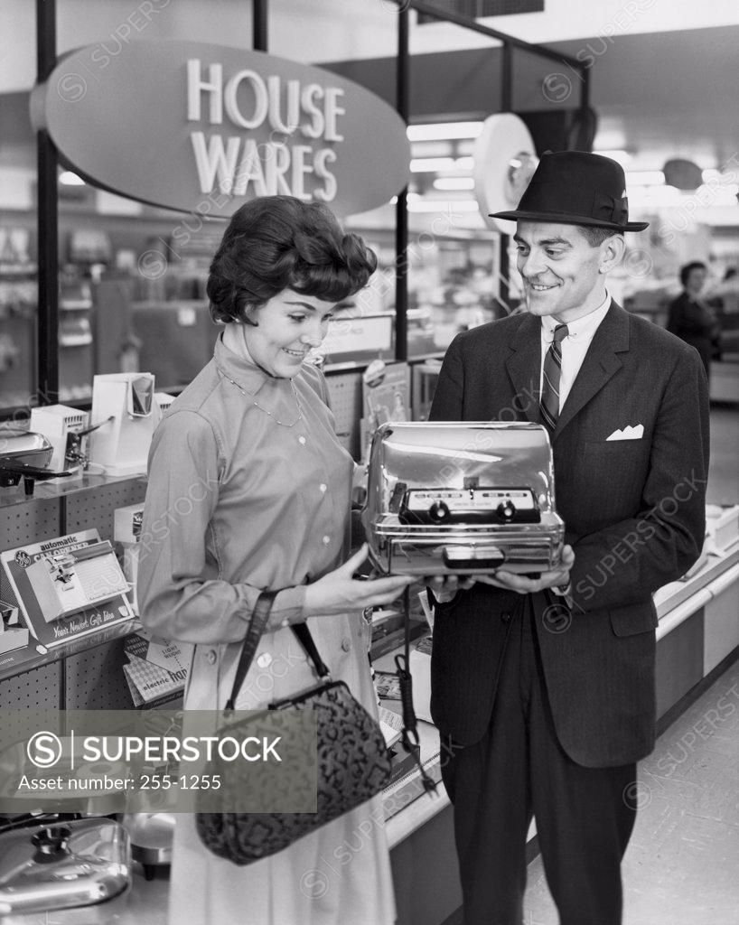 Stock Photo: 255-1255 Mid adult man showing a toaster to a mid adult woman