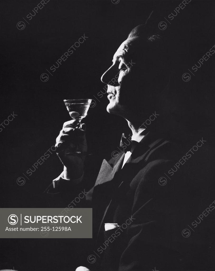 Stock Photo: 255-12598A Side profile of a mature man holding a martini