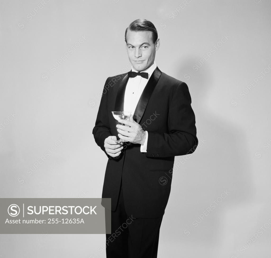 Stock Photo: 255-12635A Mid adult man holding martini