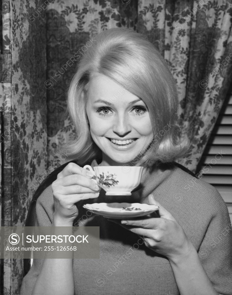 Stock Photo: 255-12656B Portrait of a young woman smiling and holding a tea cup