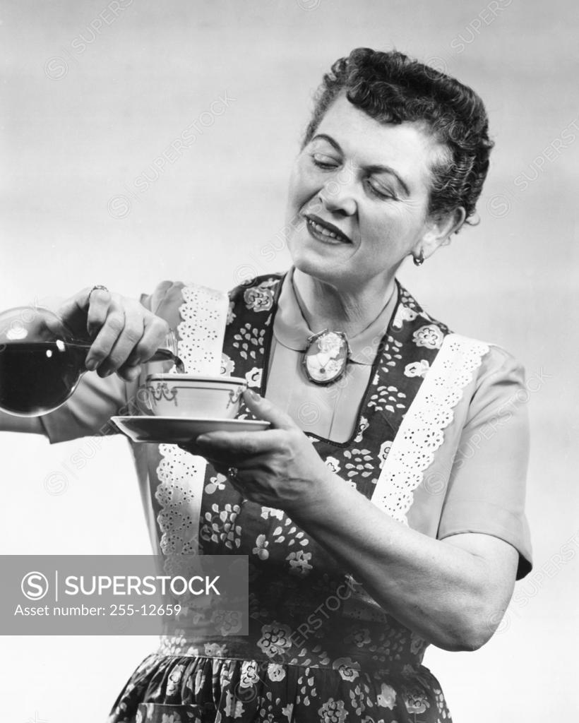 Stock Photo: 255-12659 Close-up of a mature woman pouring tea into a cup