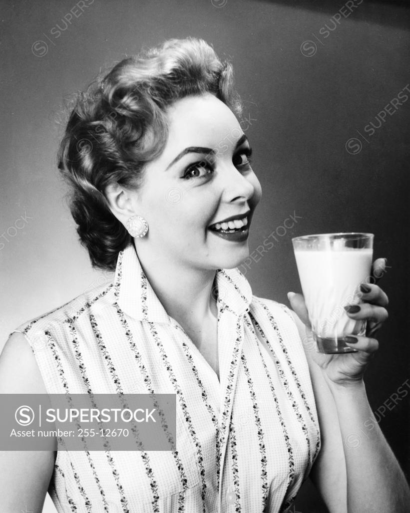 Stock Photo: 255-12670 Portrait of a young woman holding a glass of milk