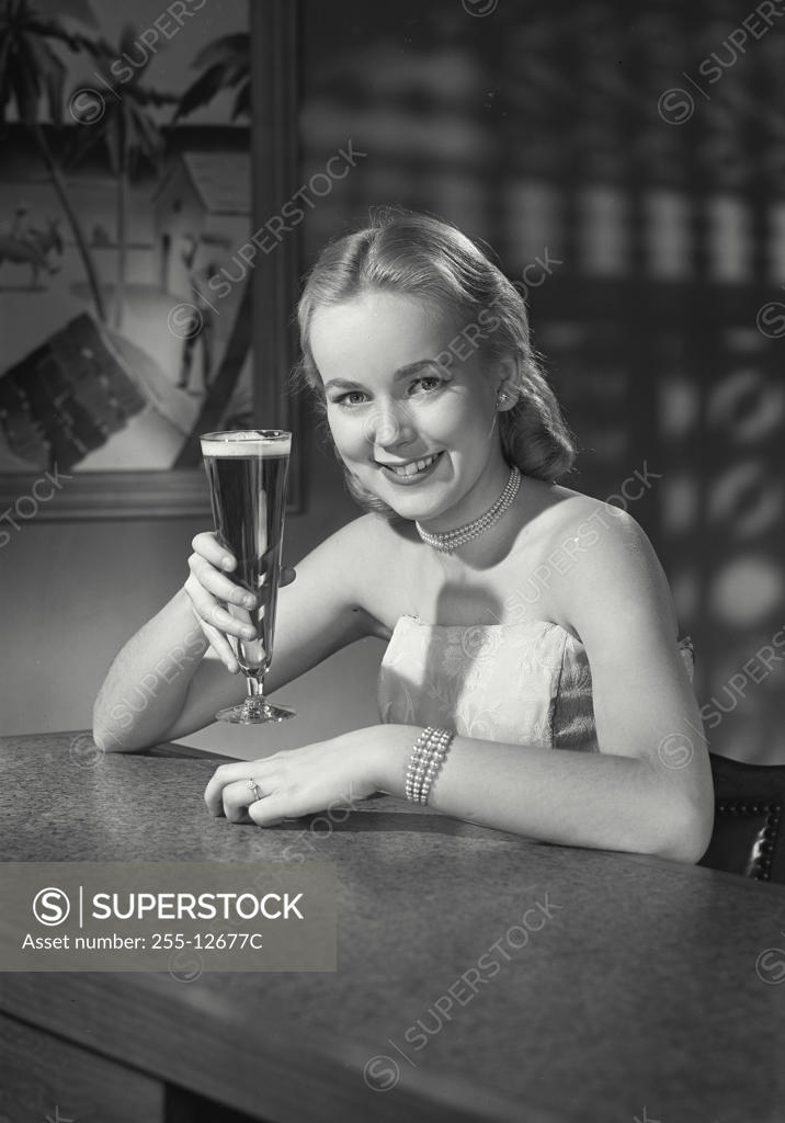 Stock Photo: 255-12677C Portrait of a young woman holding a glass of beer