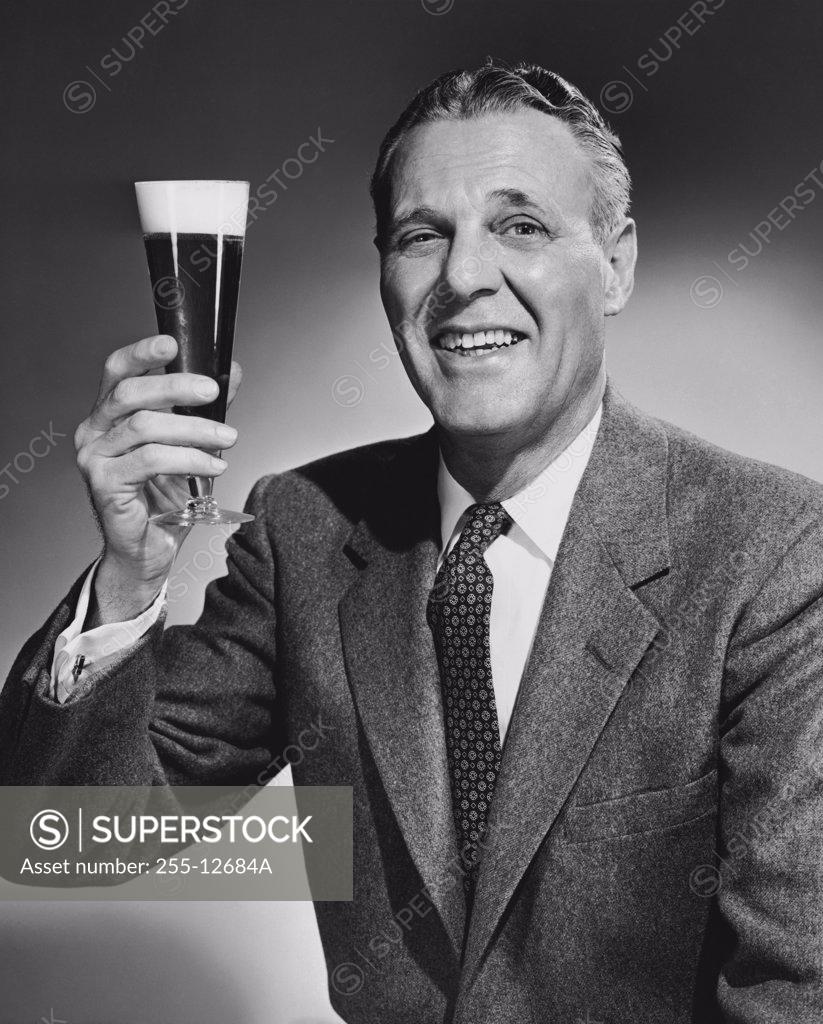 Stock Photo: 255-12684A Studio portrait of mature man holding glass of beer