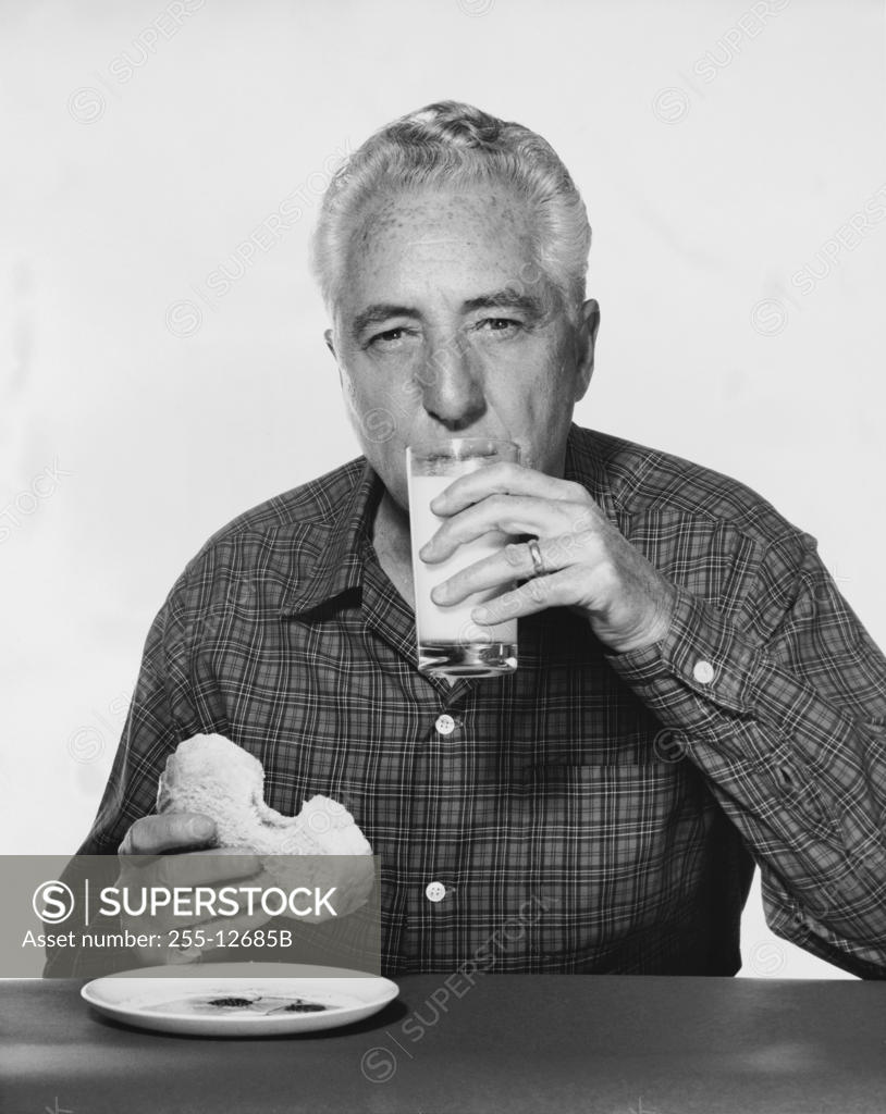 Stock Photo: 255-12685B Portrait of a mature man drinking milk and eating bread