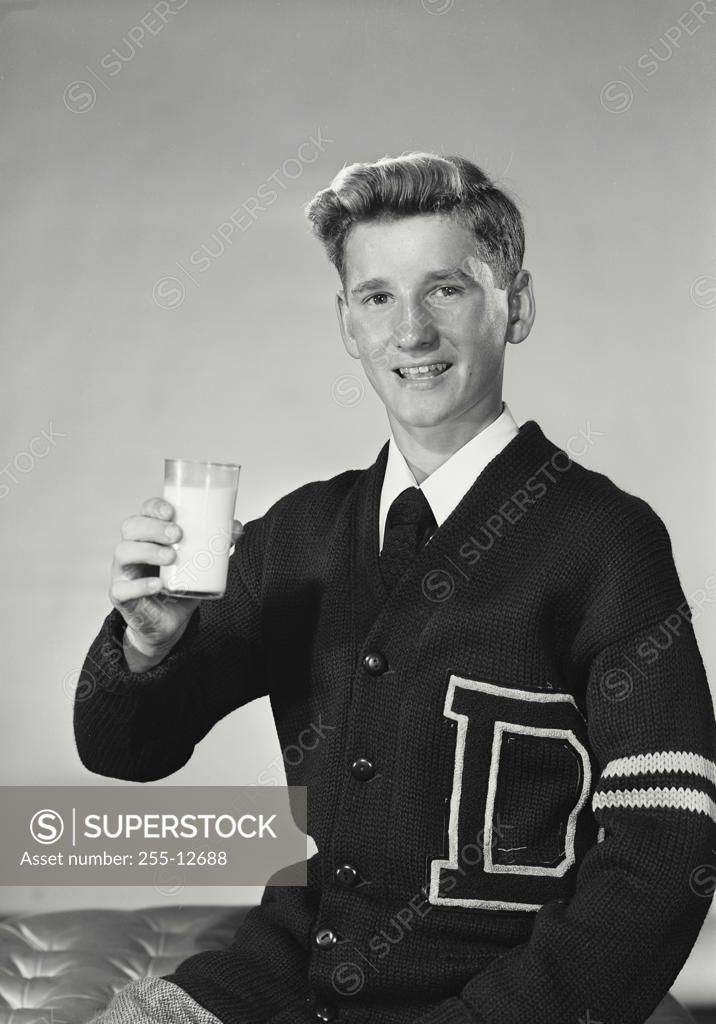 Stock Photo: 255-12688 Portrait of a teenage boy holding a glass of milk