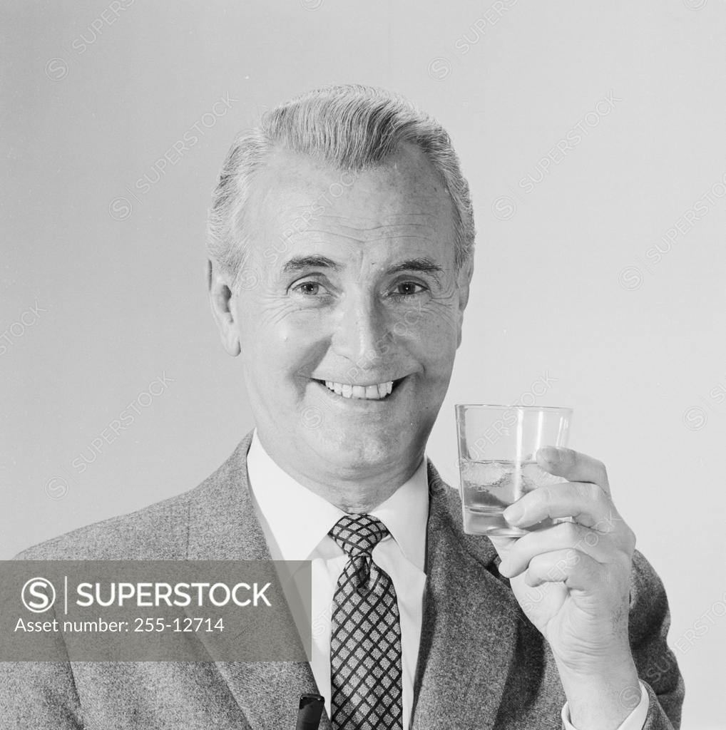 Stock Photo: 255-12714 Studio portrait of mature man holding drink