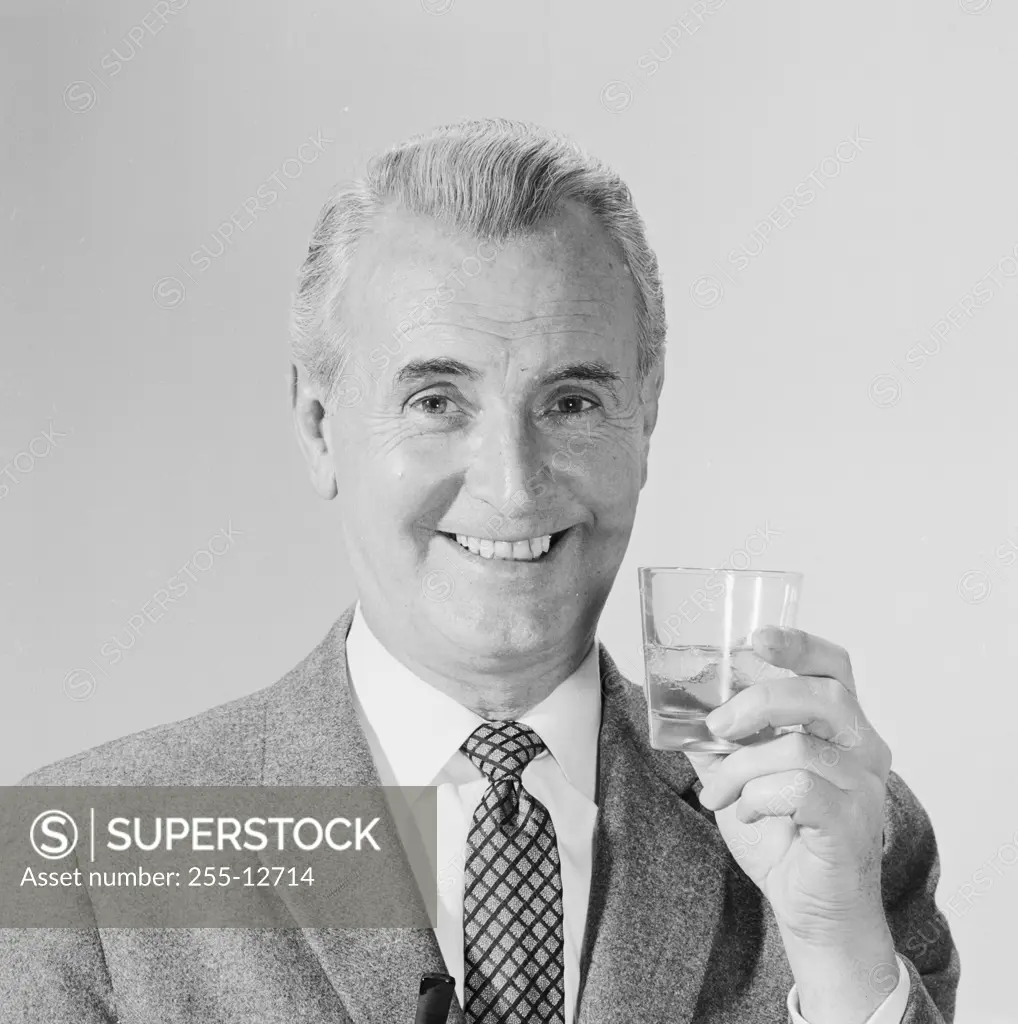 Studio portrait of mature man holding drink