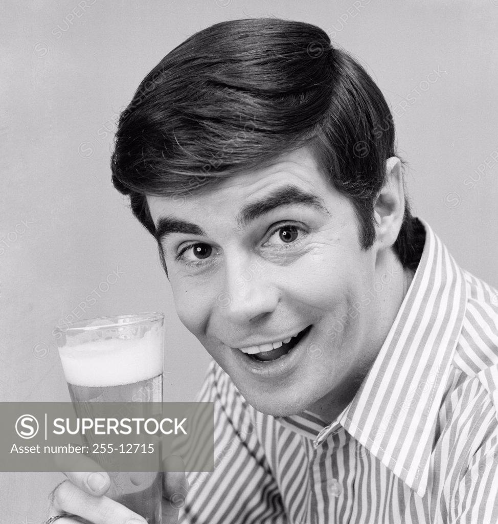 Stock Photo: 255-12715 Portrait of a young man holding a glass of beer