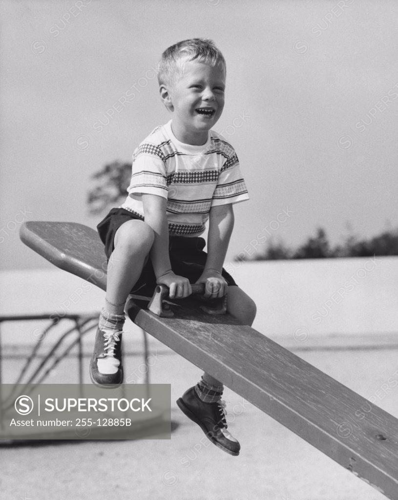 Stock Photo: 255-12885B Boy on seesaw at playground