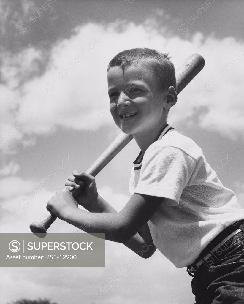 Stock Photo: 255-12900 Low angle view of a boy swinging a baseball bat