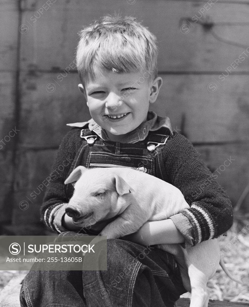 Stock Photo: 255-13605B Close-up of a boy holding a piglet and smiling