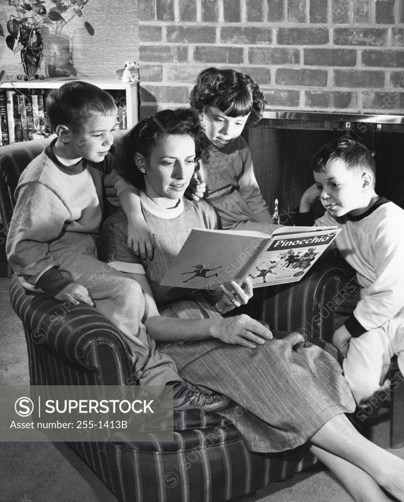 Stock Photo: 255-1413B Close-up of a mid adult woman reading a storybook with her son and daughter