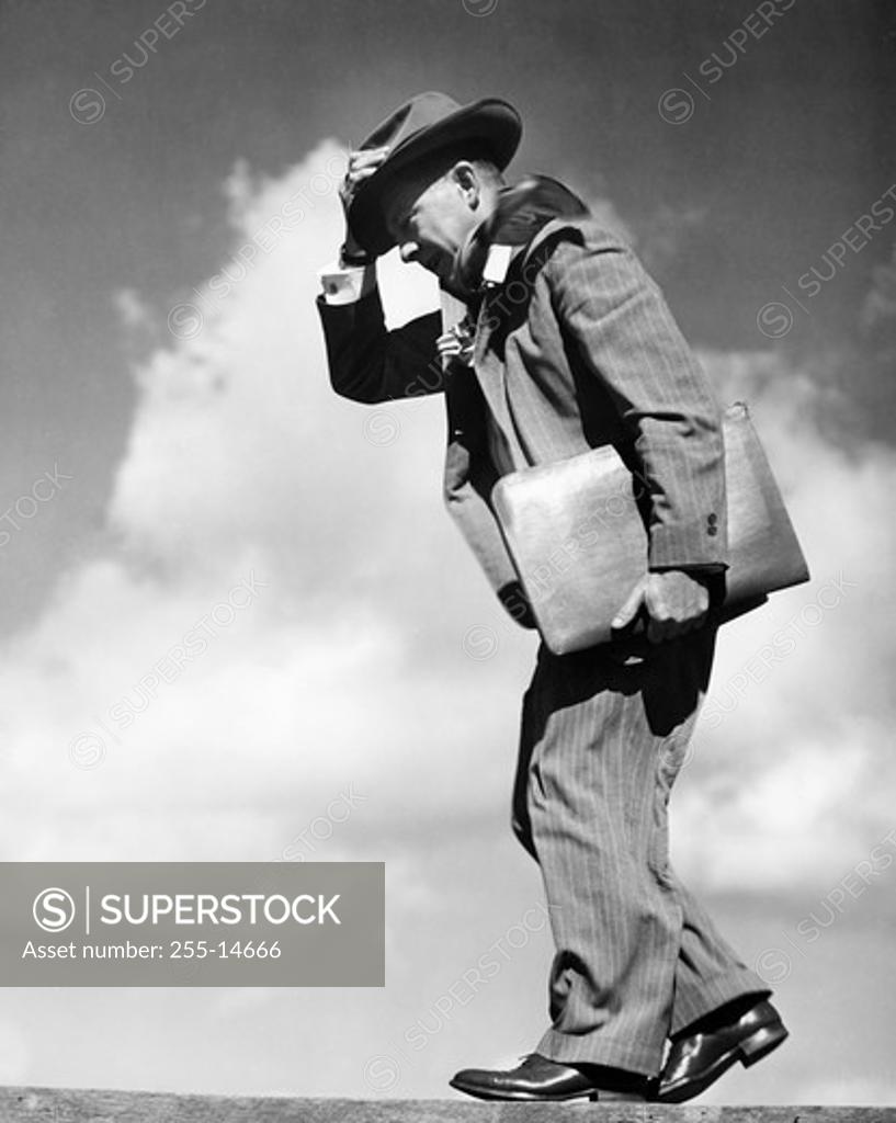 Stock Photo: 255-14666 Side profile of a mid adult man walking with files in his hand