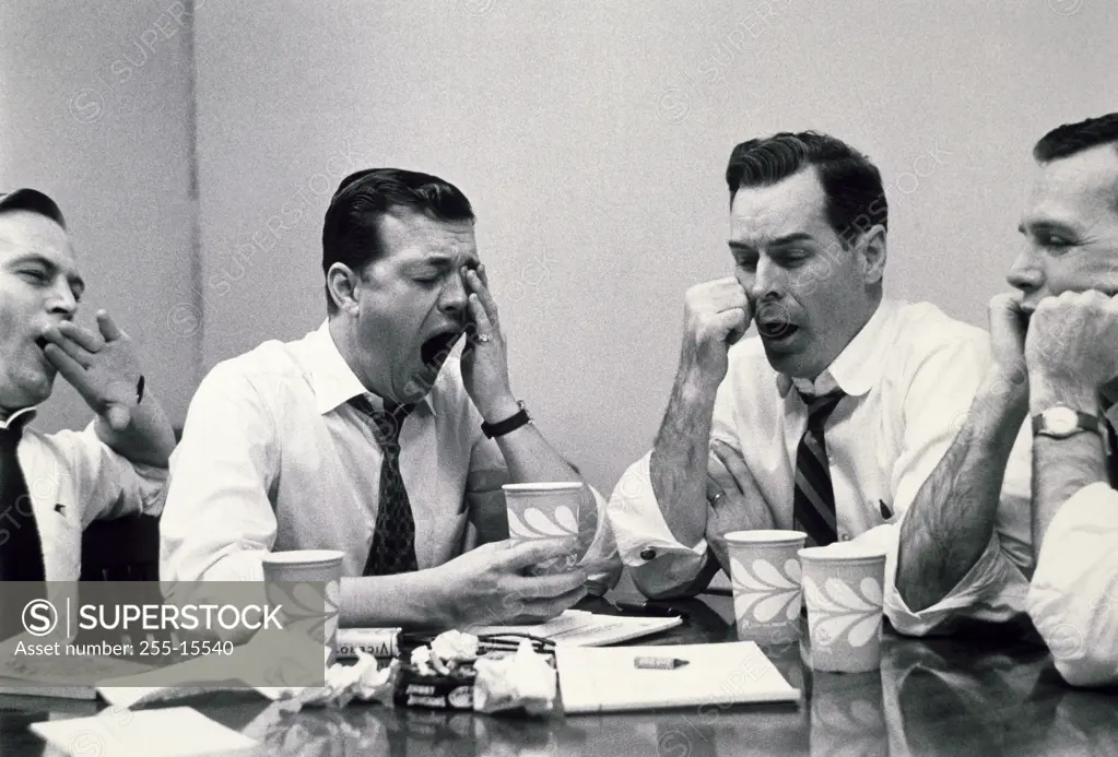 Close-up of four businessmen yawning