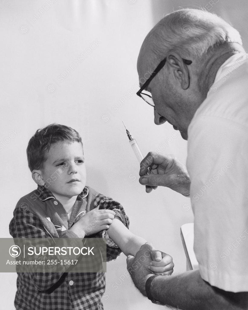 Stock Photo: 255-15617 Boy getting an injection from a male doctor