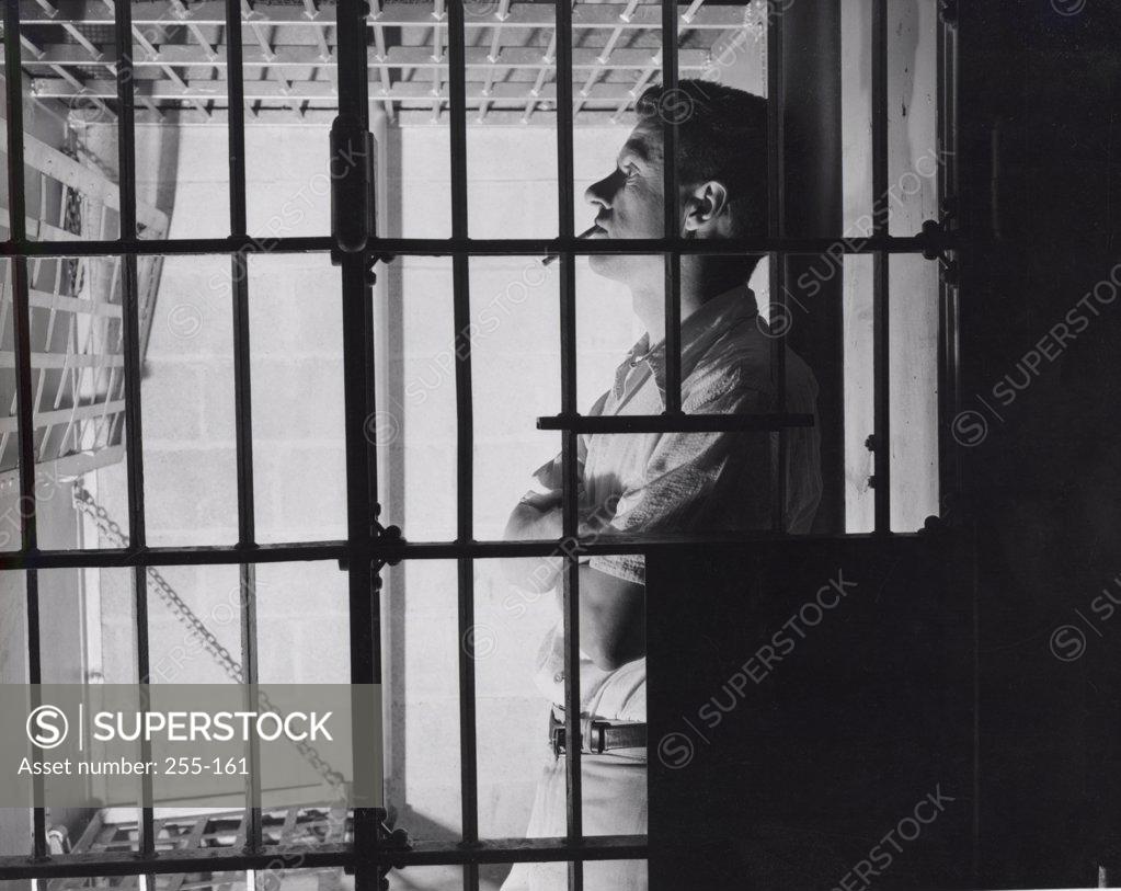 Stock Photo: 255-161 Side profile of a male prisoner smoking in a prison cell