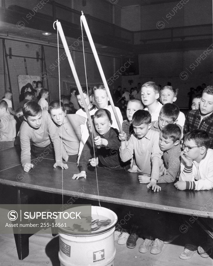 Stock Photo: 255-16561 Group of boys fishing in a bucket