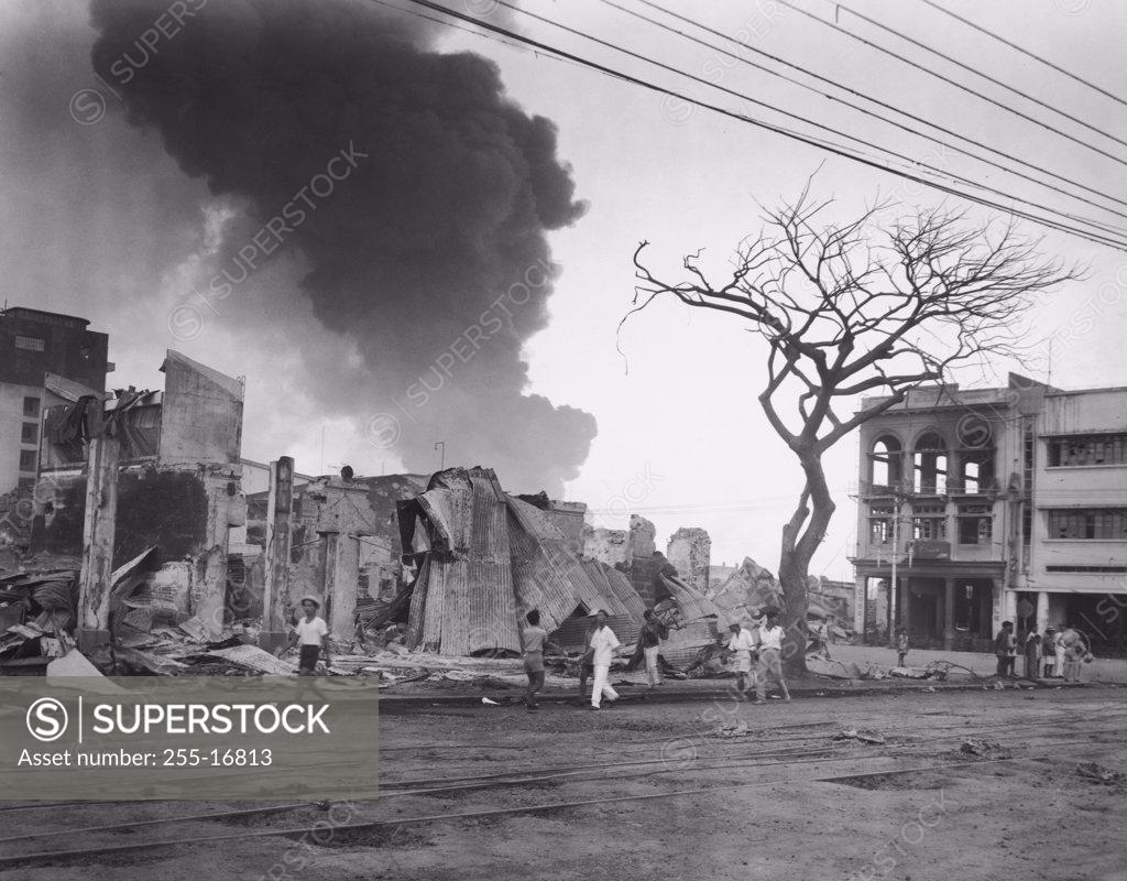 Stock Photo: 255-16813 Group of people walking in front of burning buildings, Manila, Philippines