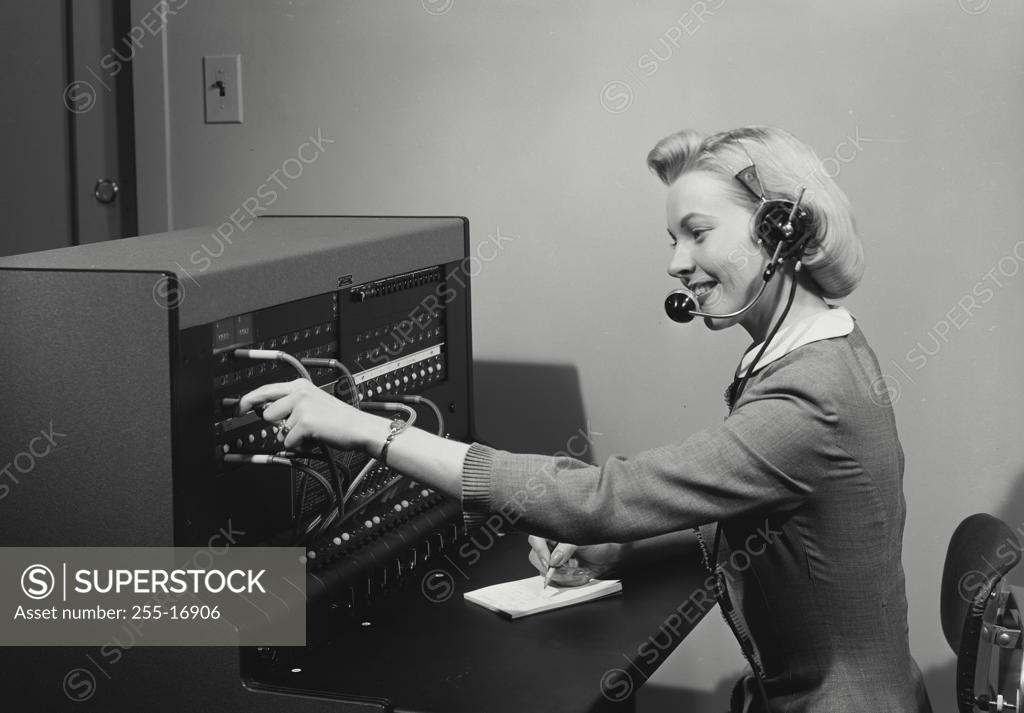 Stock Photo: 255-16906 Side profile of a female telephone operator operating a switchboard
