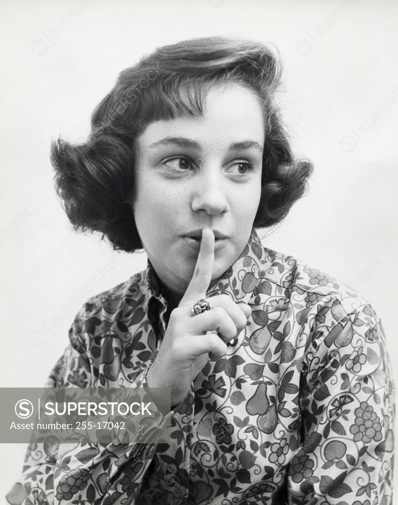 Stock Photo: 255-17042 Close-up of a teenage girl with her finger on her lips