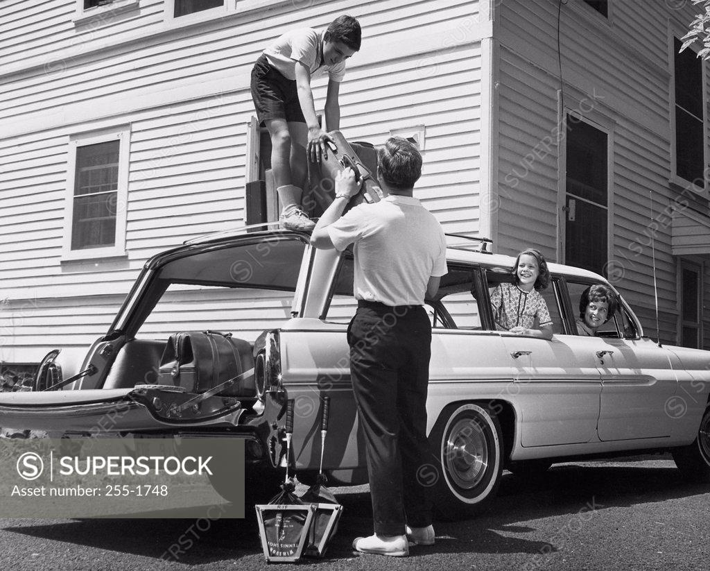 Stock Photo: 255-1748 Son helping his father load luggage onto a car