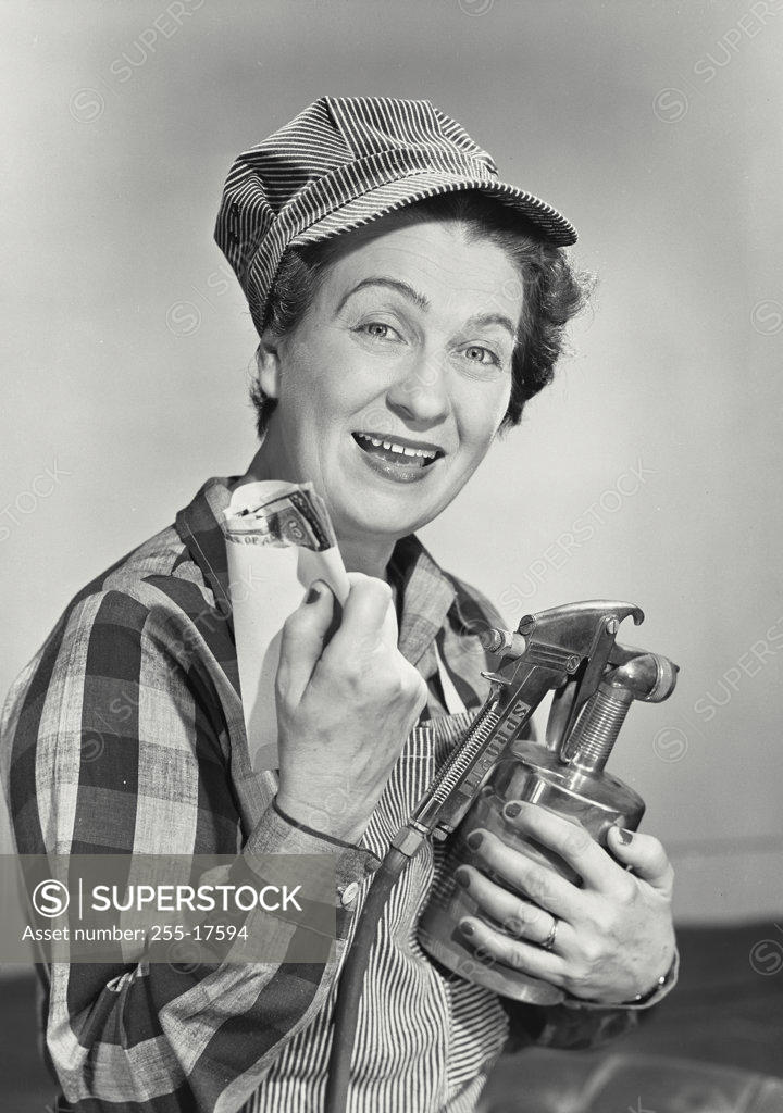Stock Photo: 255-17594 Portrait of a female painter holding a paint spray gun, 1950
