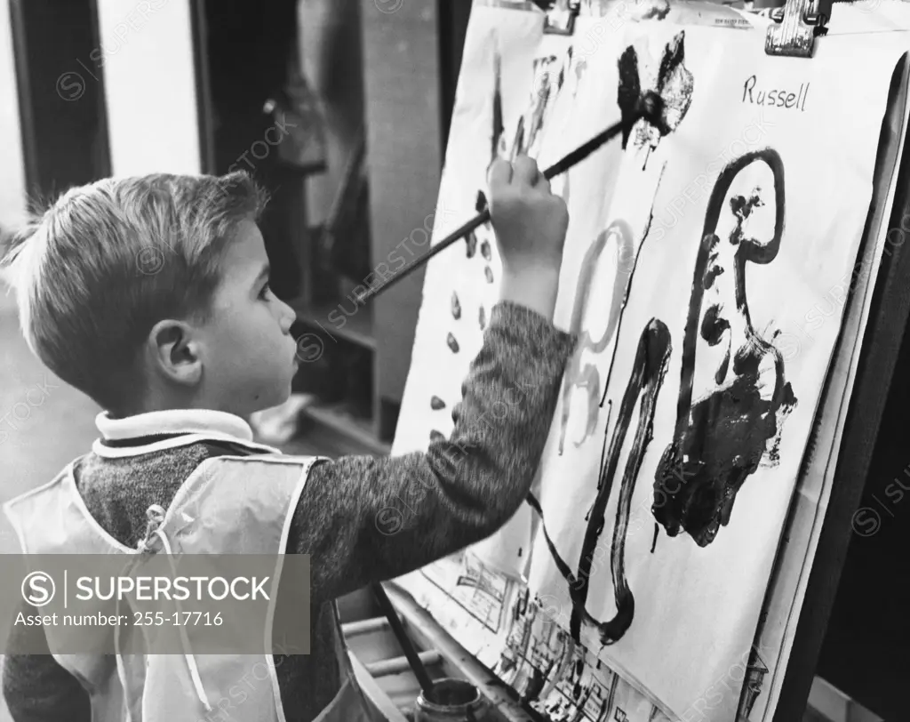 Side profile of a boy painting on a canvas