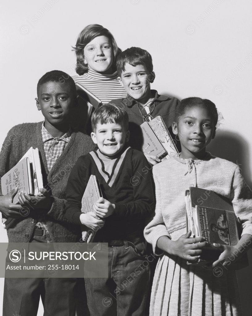 Stock Photo: 255-18014 Schoolboys and schoolgirls holding books and smiling