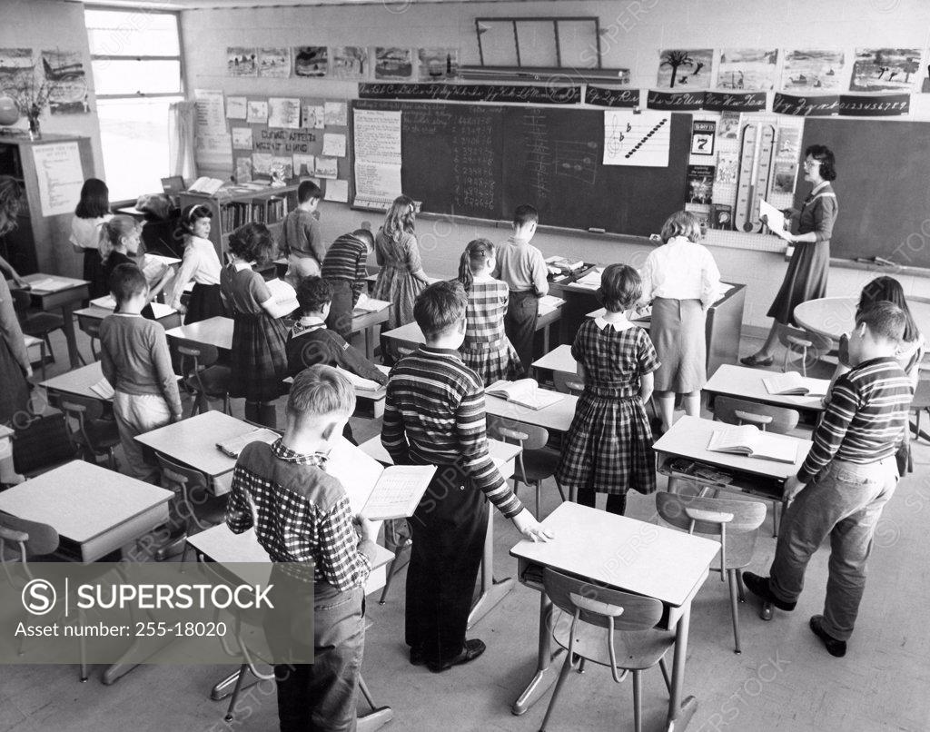 Stock Photo: 255-18020 School children standing in a classroom with a female teacher