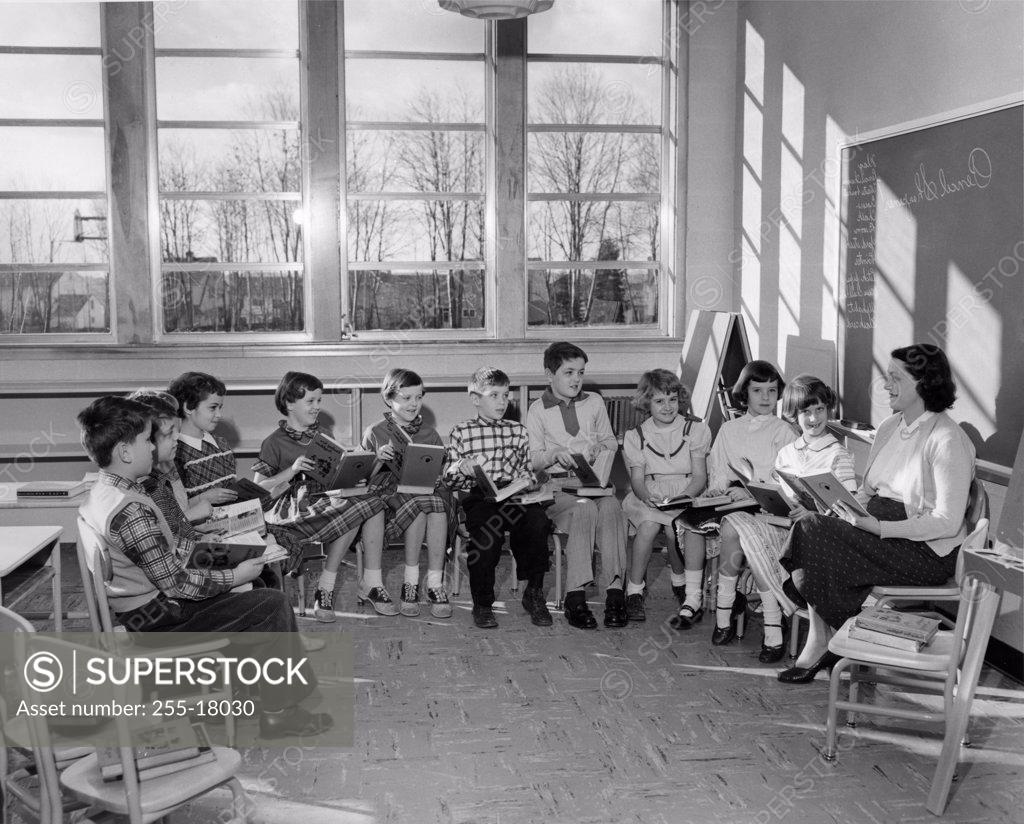 Stock Photo: 255-18030 School children reading with their teacher