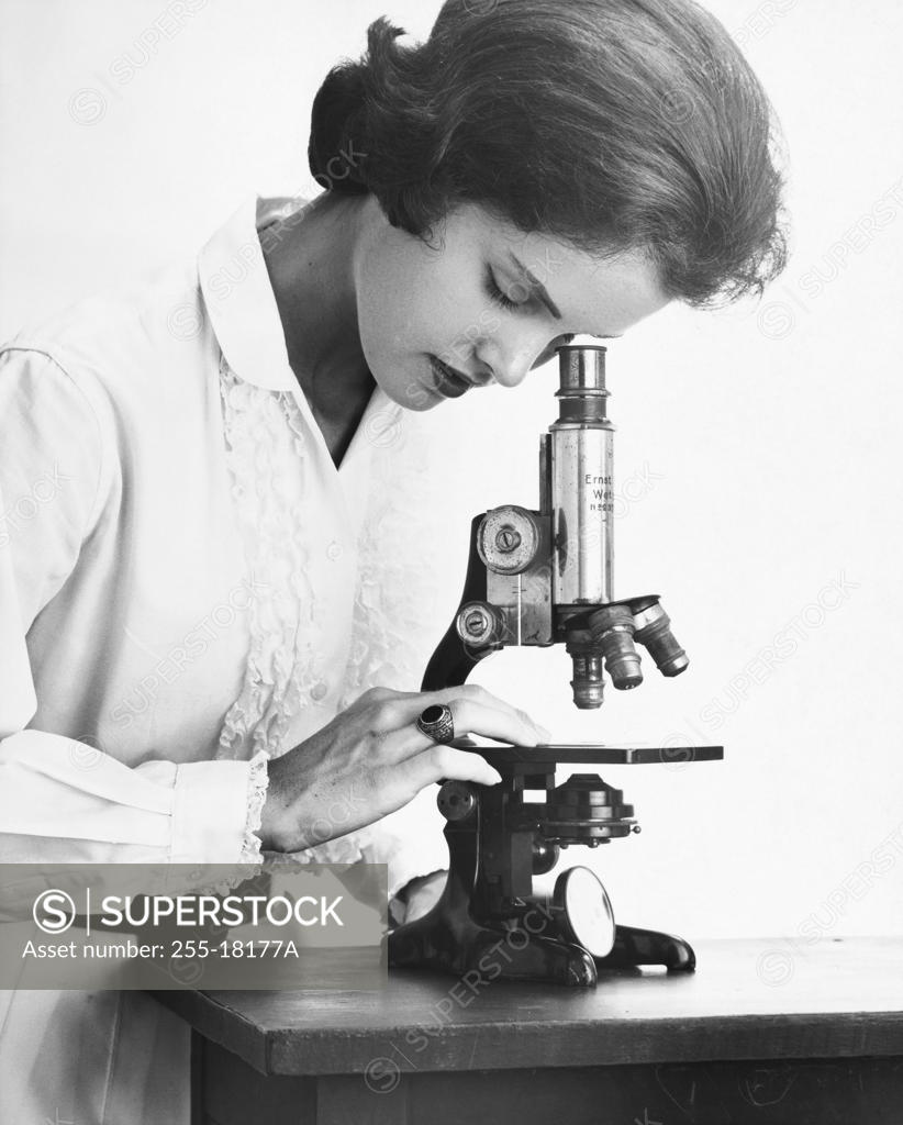 Stock Photo: 255-18177A Teenage girl looking through a microscope