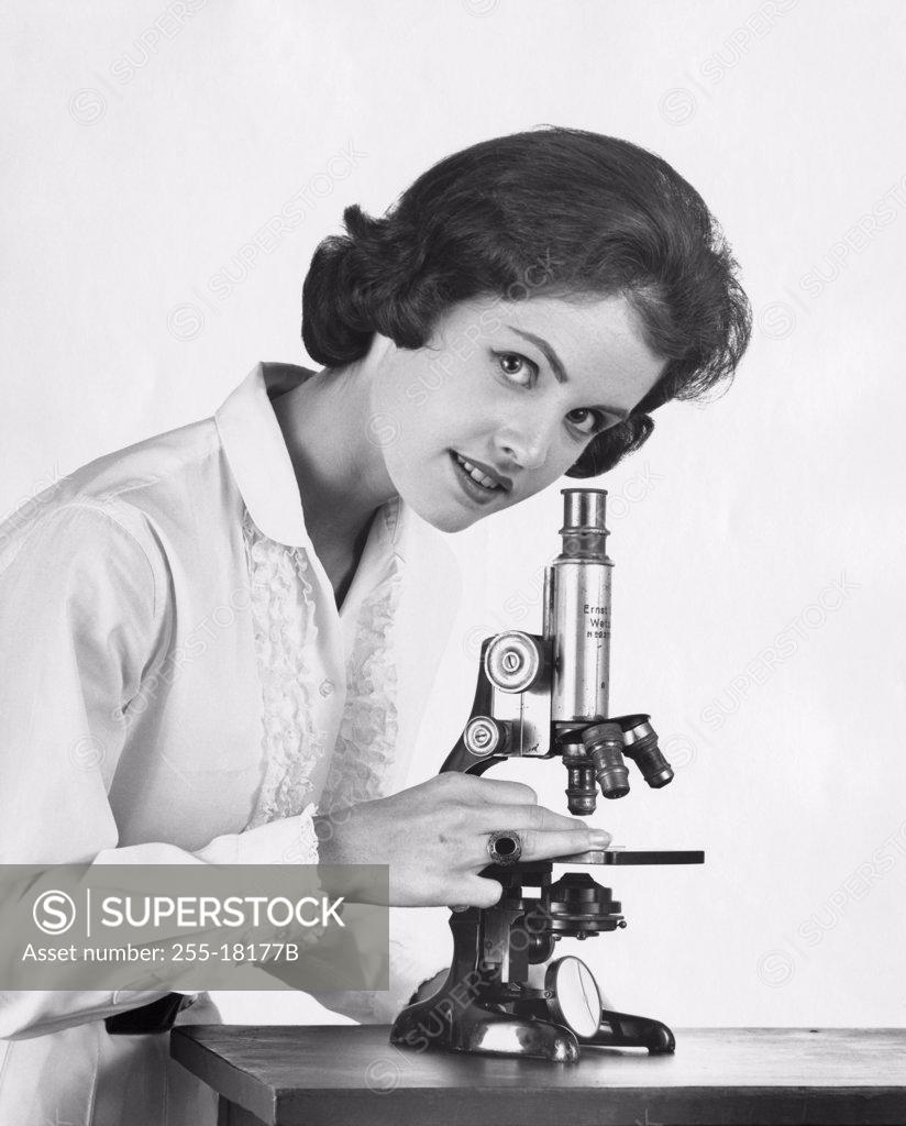 Stock Photo: 255-18177B Teenage girl standing near a microscope