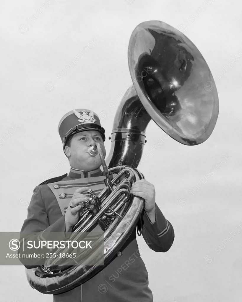 Low angle view of a young man playing the tuba