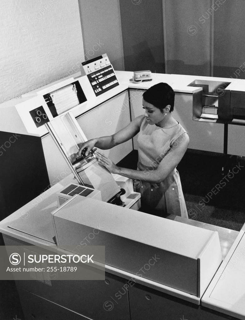 Stock Photo: 255-18789 High angle view of a businesswoman working on a data processing system, 1968