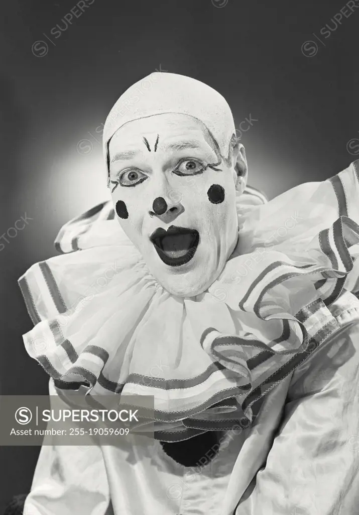Vintage photograph. Portrait of clown in collar with mouth open.