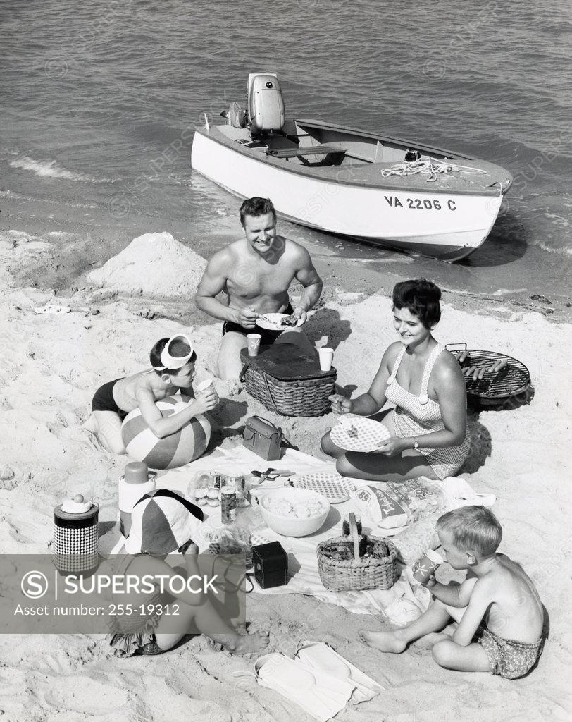 Stock Photo: 255-19312 Parents with three children having picnic on beach