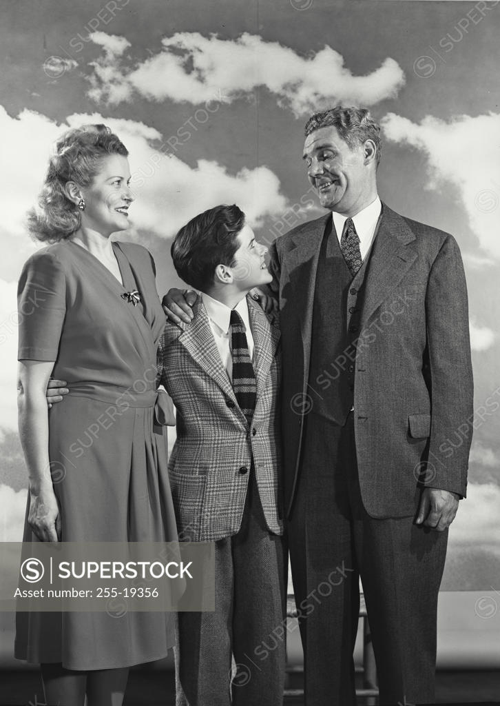 Stock Photo: 255-19356 Mature couple standing with their son and smiling
