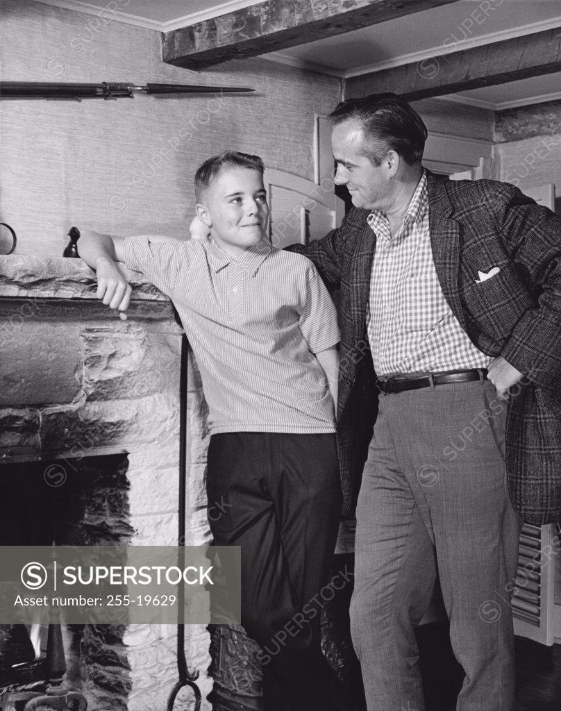 Stock Photo: 255-19629 Father standing with his son near a fireplace
