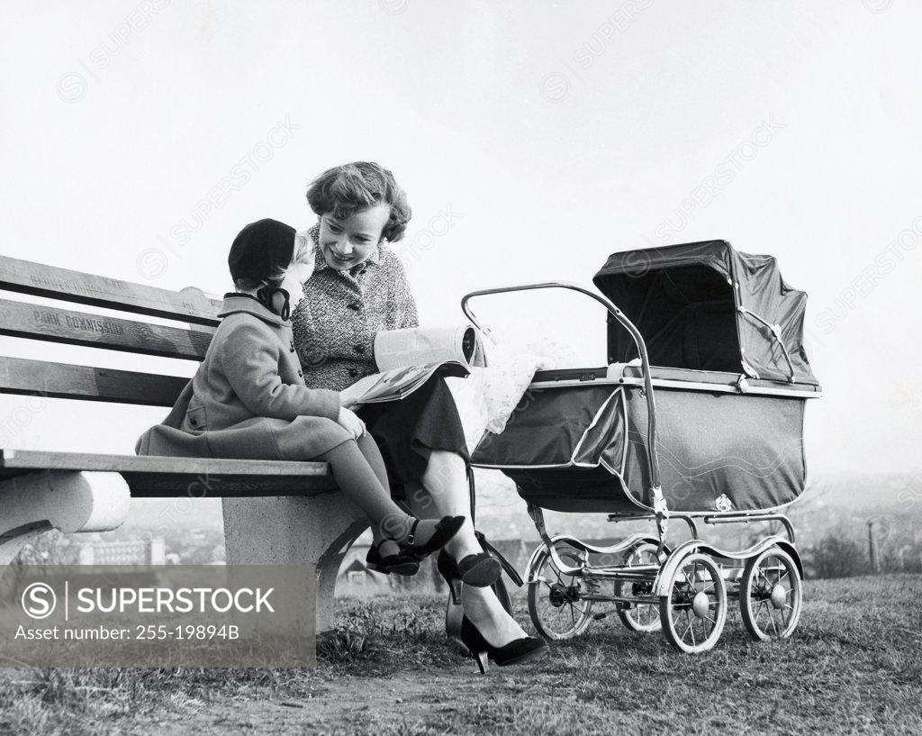 Stock Photo: 255-19894B Mother sitting with her daughter reading a book