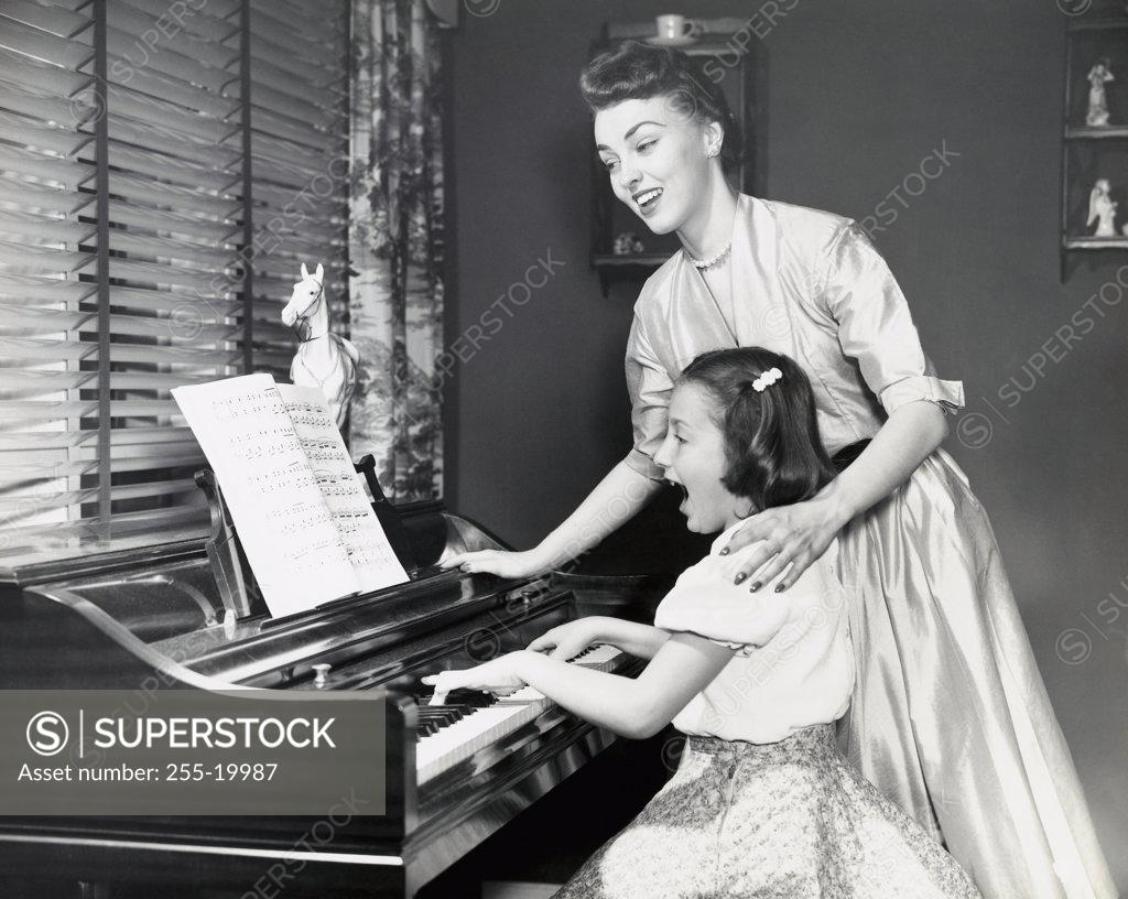 Stock Photo: 255-19987 Close-up of mother teaching daughter to play piano