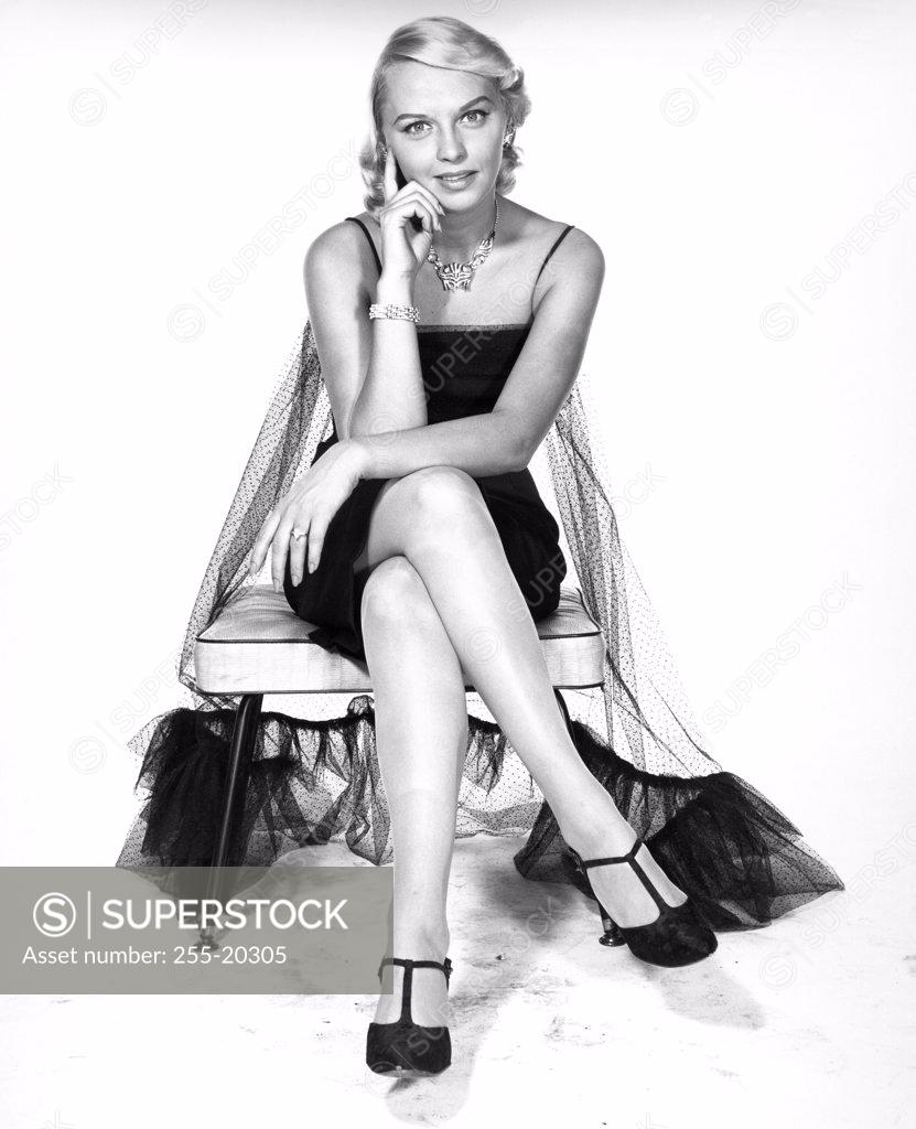 Stock Photo: 255-20305 Young woman sitting on a chair
