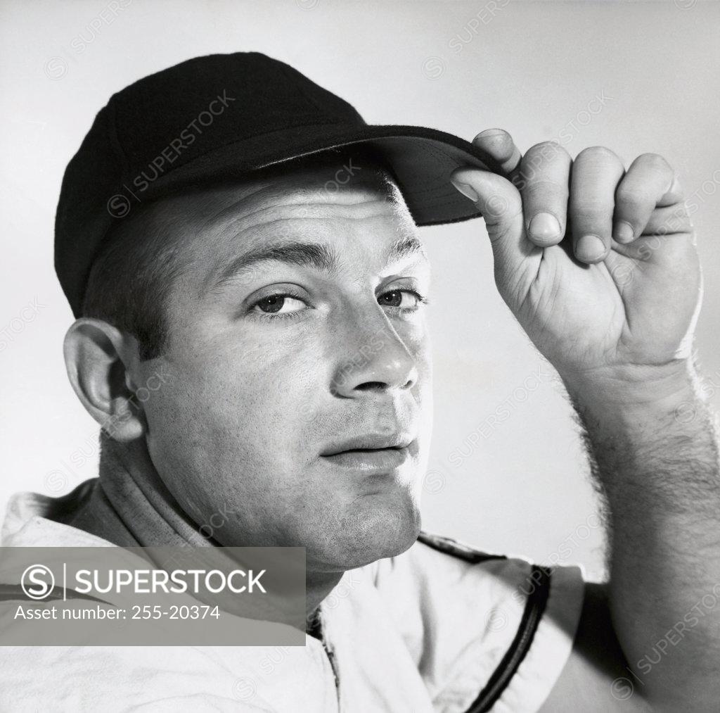 Stock Photo: 255-20374 Portrait of a young man adjusting his cap