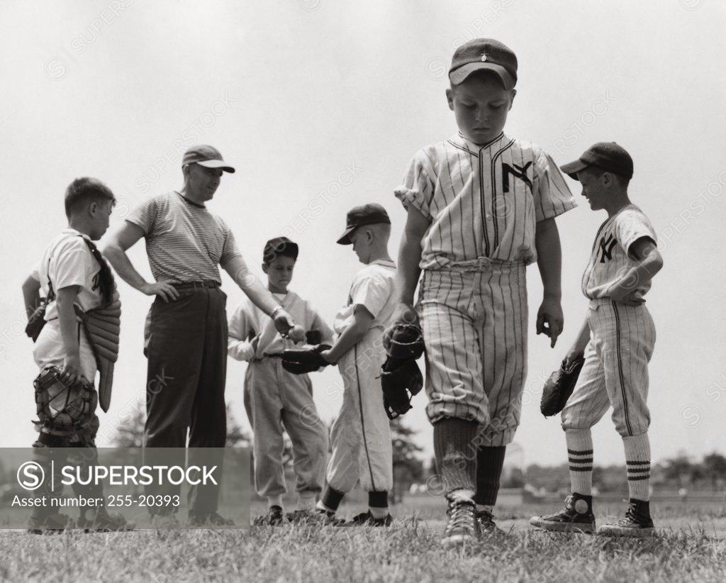 Stock Photo: 255-20393 Boy expelled from youth league walking away from his team and coach