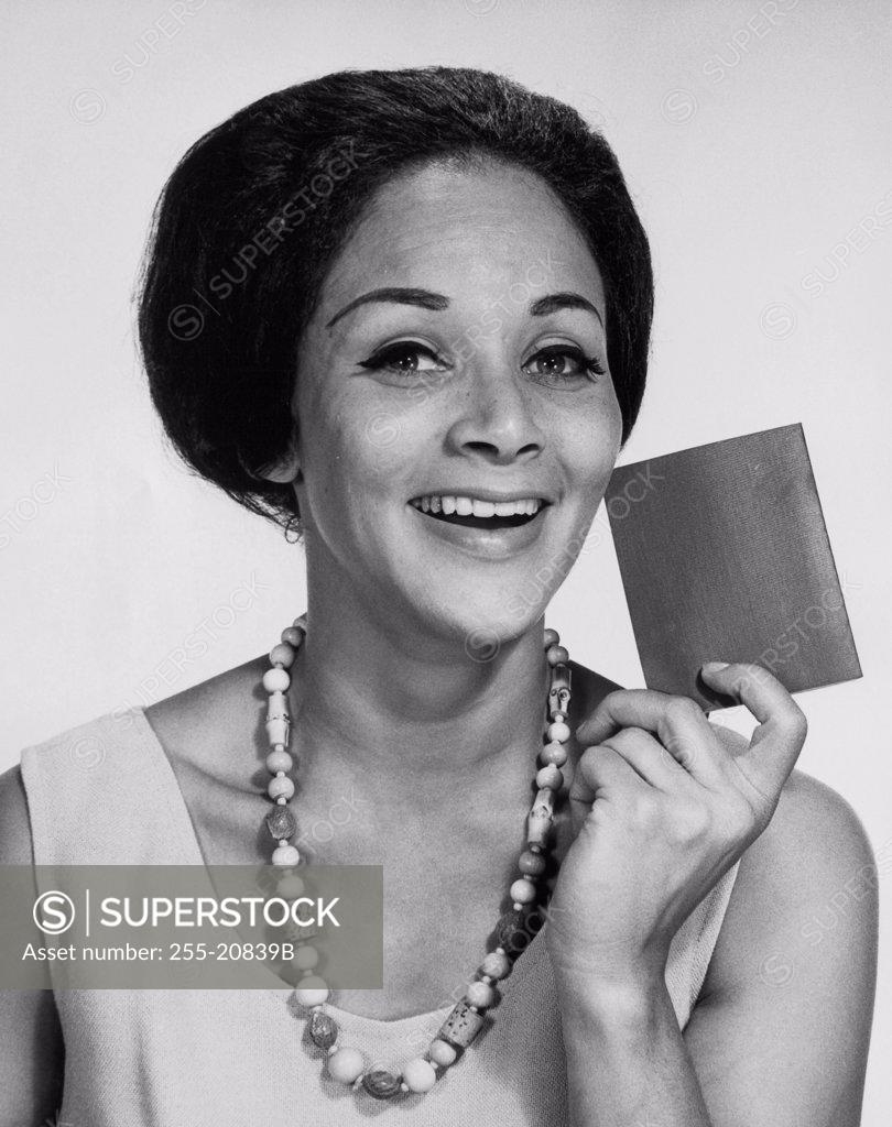 Stock Photo: 255-20839B Portrait of a young woman holding a wallet and smiling