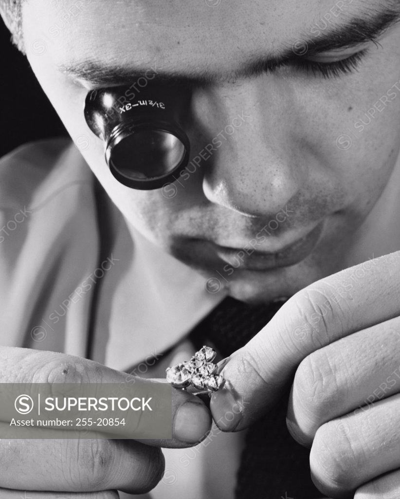 Stock Photo: 255-20854 Close-up of a mid adult man inspecting a diamond ring